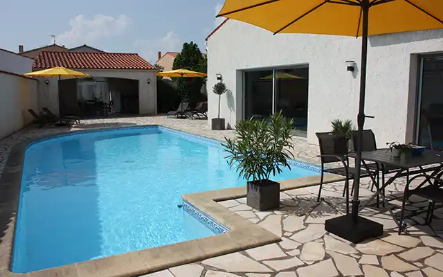 Vue de la terrasse et des transats de la piscine